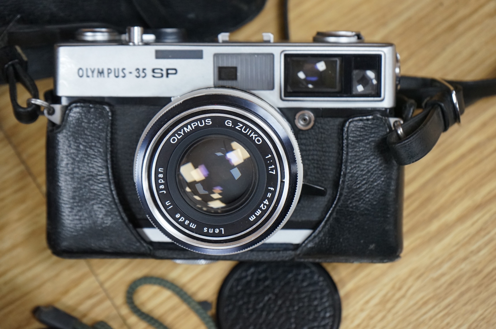 A cased Olympus 35SP camera, together with two more recent digital cameras